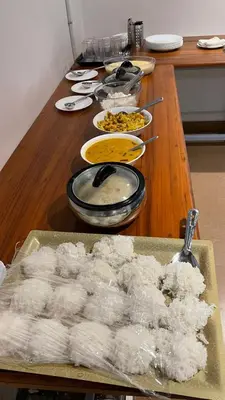 a wooden table with a bunch of food on it at Ayla Homes in Madikeri
