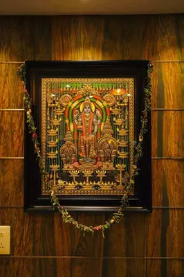 a painting of a god in a frame on a wall at Geetha Govindham in Guruvāyūr