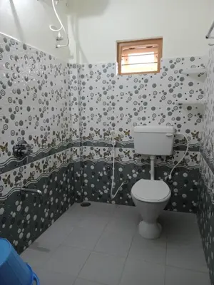 a bathroom with a toilet and a shower at Krishna Kuteera in Siddapur