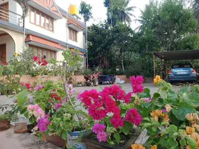 a garden of flowers in front of a building at Krishna Kuteera in Siddapur