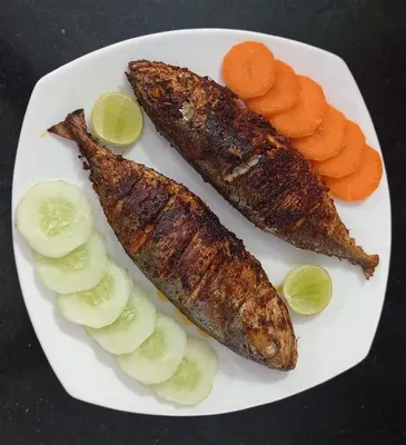 two fish and carrots on a white plate at Perch by the sea in Kannur