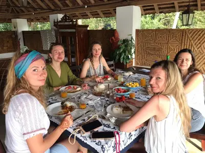 a group of women sitting around a table eating food at Vala House in Cherai Beach