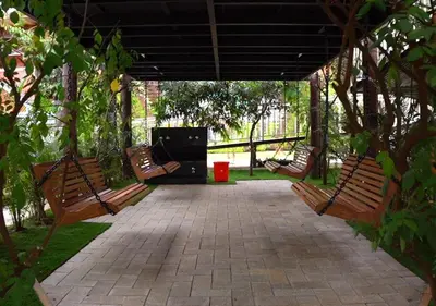 a group of benches sitting under a pavilion at Feliz Homes- Near to Kottakkal Arya Vaidya Sala in Kottakkal