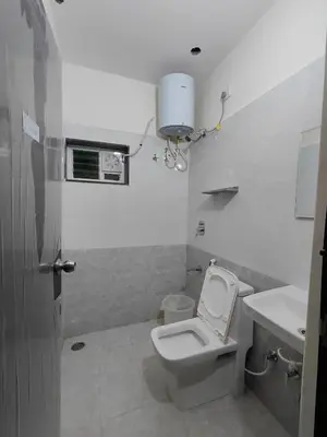 a white bathroom with a toilet and a sink at Minimal Poshtel in Mysore