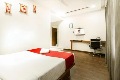 a bedroom with a bed and a desk with a computer at KINGS CALICUT in Kozhikode