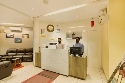 two men standing at a counter with a computer at KINGS CALICUT in Kozhikode