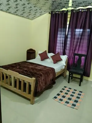 a bedroom with a bed with purple curtains and a chair at SAMZ ESTATE Stay 3BHK in Madikeri