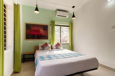 a bedroom with a bed with green and white walls at Ecoville suites in Kozhikode