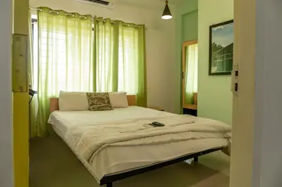 a bedroom with a large bed in front of a window at Ecoville suites in Kozhikode