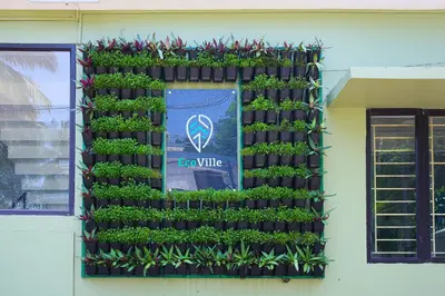 a wall of plants on the side of a building at Ecoville suites in Kozhikode