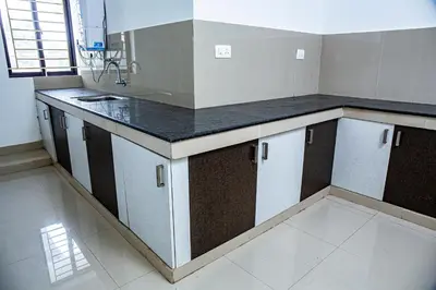 a kitchen with a black and white counter top at Ecoville suites in Kozhikode