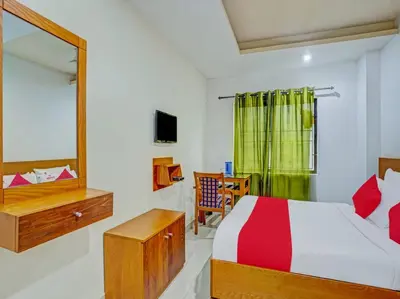 a bedroom with a bed and a mirror at Marhaba Tourist Home in Kozhikode