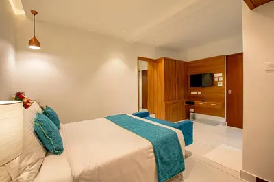 a hotel room with a bed and a television at Harivaram Yuga in Guruvāyūr