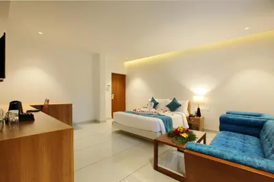 a hotel room with a bed and a blue couch at Harivaram Yuga in Guruvāyūr