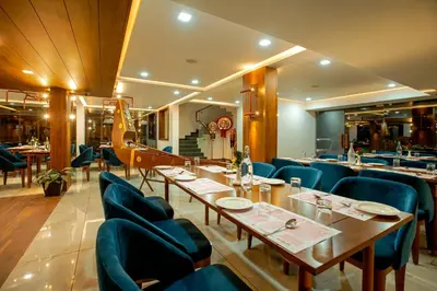 a restaurant with blue chairs and tables in a room at Harivaram Yuga in Guruvāyūr