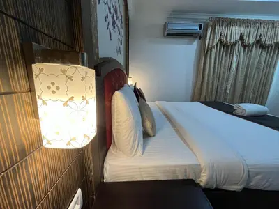 a hotel room with a bed and a lamp at Gee Bee Palace in Angamali