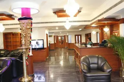 a lobby with chairs and a bar in a hospital at Gee Bee Palace in Angamali
