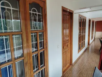 a room with wooden doors and a hallway at Shivalaya Homestay in Madikeri
