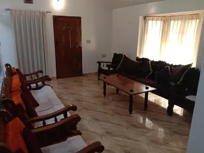 a living room with a couch and a coffee table at Shivalaya Homestay in Madikeri