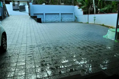 a brick parking lot with a car parked on it at Saaketh Holiday Home in Kozhikode