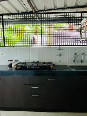 a kitchen with a black counter top and a sink at Saaketh Holiday Home in Kozhikode