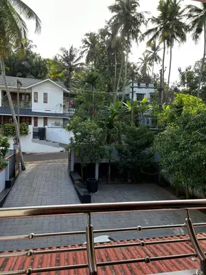 a view from a balcony of a house with palm trees at Saaketh Holiday Home in Kozhikode