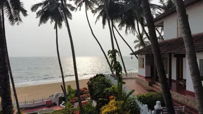 a house on the beach with palm trees and the ocean at Willo Stays On the beach Sea view Ocean Hues holiday home in Kannur