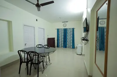 a dining room with a table and some chairs at Toms Villa along National highway Thrissur at Nadathara in Trichūr