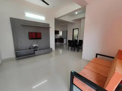 a living room with a couch and a dining room at Meer Stay - Premium Service Apartments in Vānivilāsa Puram