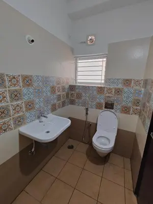 a bathroom with a toilet and a sink at Meer Stay - Premium Service Apartments in Vānivilāsa Puram