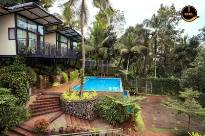 a house with a swimming pool in front of it at Miracle Hotel and Resorts in Kozhikode