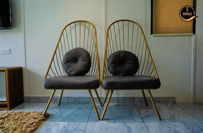 two chairs with black cushions sitting next to each other at Miracle Hotel and Resorts in Kozhikode