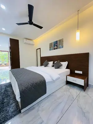 a bedroom with a large bed and a ceiling fan at Miracle Hotel and Resorts in Kozhikode
