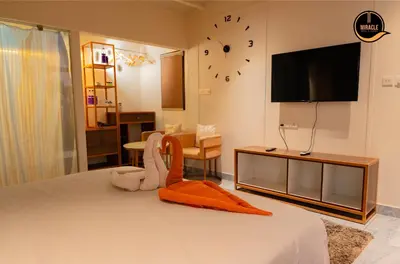 a bedroom with a bed with a tv on the wall at Miracle Hotel and Resorts in Kozhikode