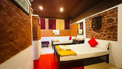 a room with a bed and a table in it at Wild Elephant Resort in Kallar Vattiyar