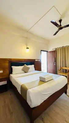 a bedroom with a large bed with a ceiling fan at Wild Elephant Resort in Kallar Vattiyar