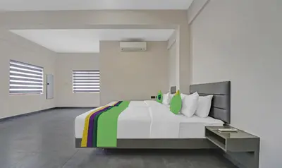 a bedroom with a large bed with white sheets and colorful pillows at Treebo Grand Vistara Airport Suites in Cochin