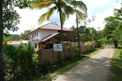a house with a sign on the side of a road at Greenhouse Homestay in Siddapur