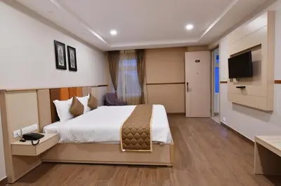 a hotel room with a bed and a flat screen tv at Soho Boutique Hotel in Mysore