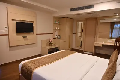 a hotel room with a bed and a television at Soho Boutique Hotel in Mysore