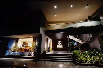a lobby of a building with stairs and plants at Soho Boutique Hotel in Mysore