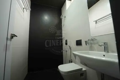 a bathroom with a white toilet and a sink at Hotel Cineplex in Coimbatore