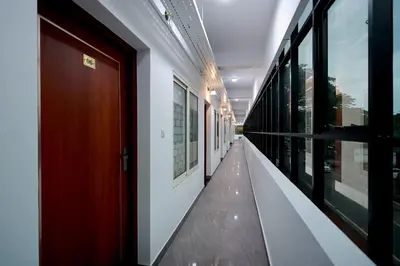 a hallway of a building with a red door and windows at Isha Residency in Alwaye