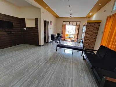 a living room with a couch and a table at Yellow House in Mysore