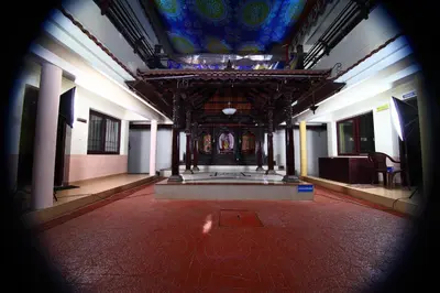a large room with a ceiling with a painting on it at Guruvayoor Resort in Guruvāyūr