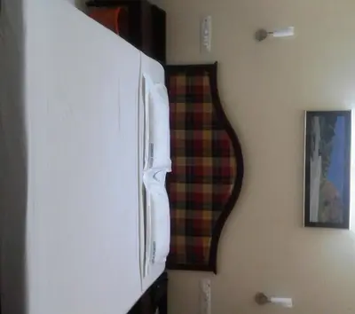 a white refrigerator freezer sitting next to a wall at Guruvayoor Resort in Guruvāyūr
