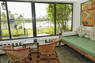 a living room with a couch and chairs and windows at Vala House - Full Villa in Pallipuram
