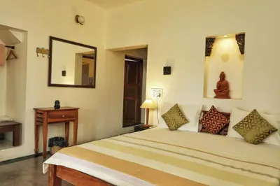 a bedroom with a large bed and a mirror at Vala House - Full Villa in Pallipuram