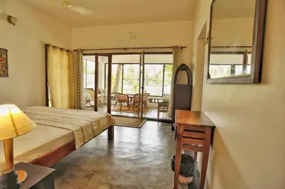 a bedroom with a bed and a table and a room at Vala House - Full Villa in Pallipuram