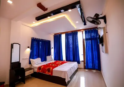 a bedroom with a bed with blue drapes at Dakshinakasi Guest House in Thirunelli